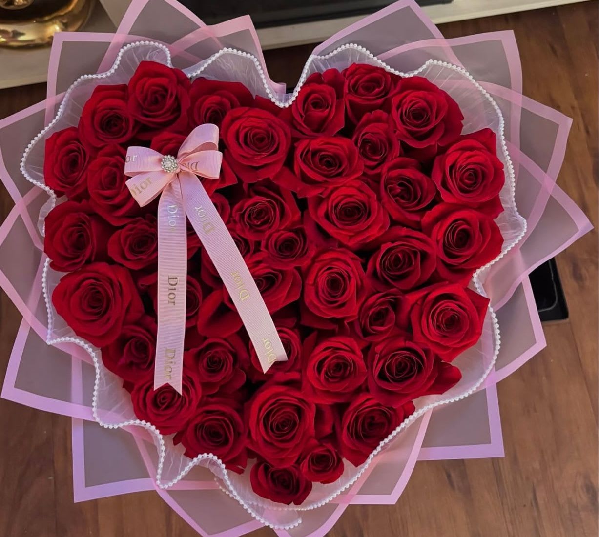 Heart-shaped bouquet of red roses with pink ribbon wrapping