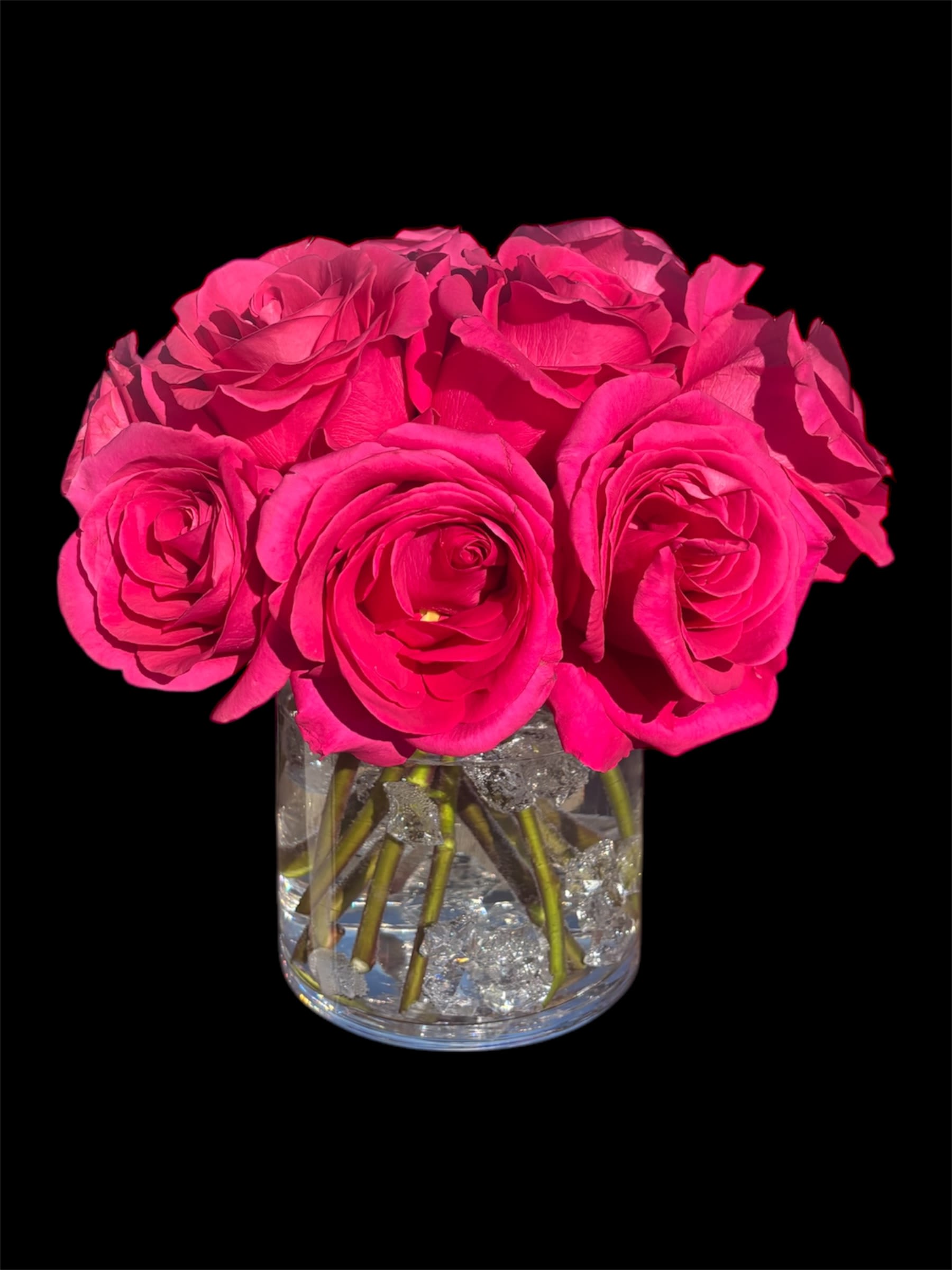 Hot pink roses arranged in a clear glass vase
