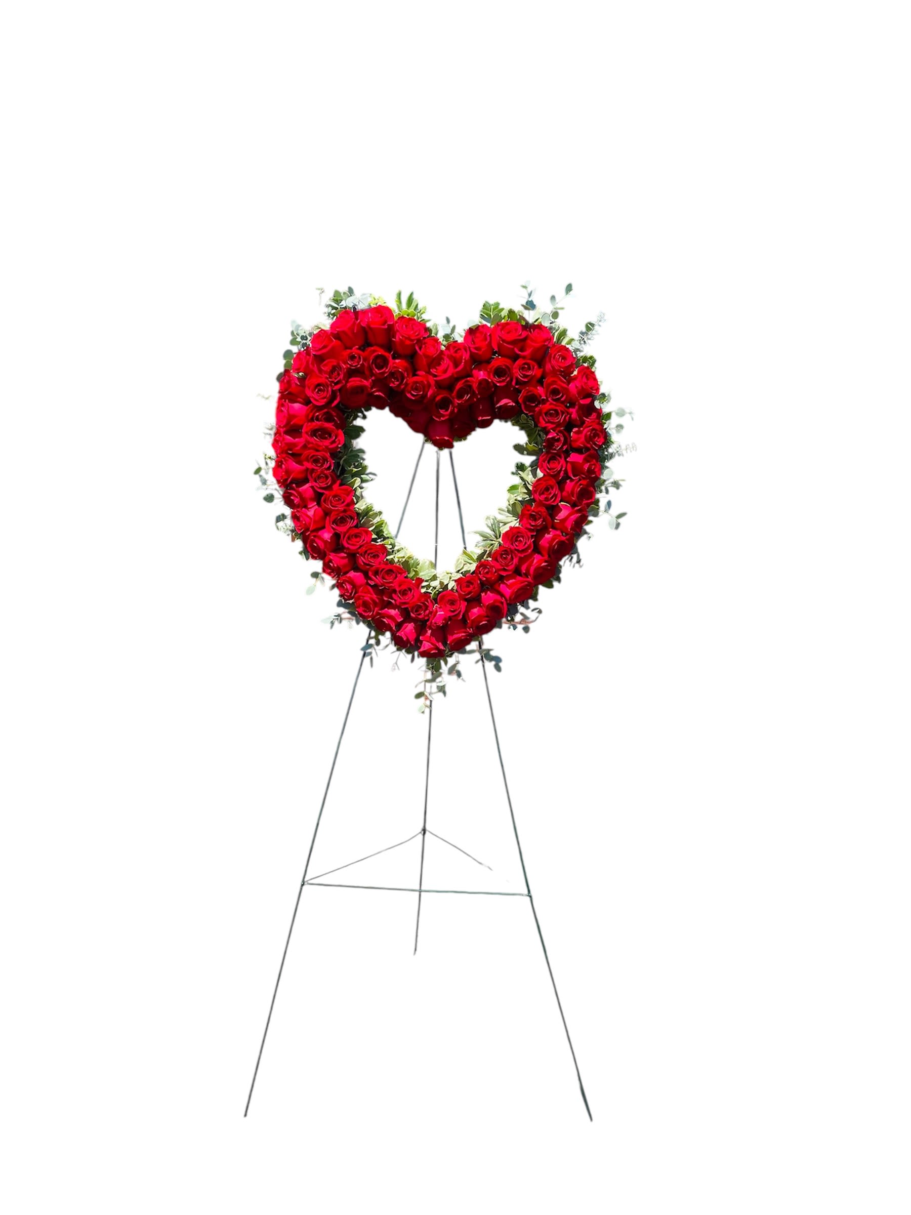 Heart-shaped standing wreath of red roses on an easel