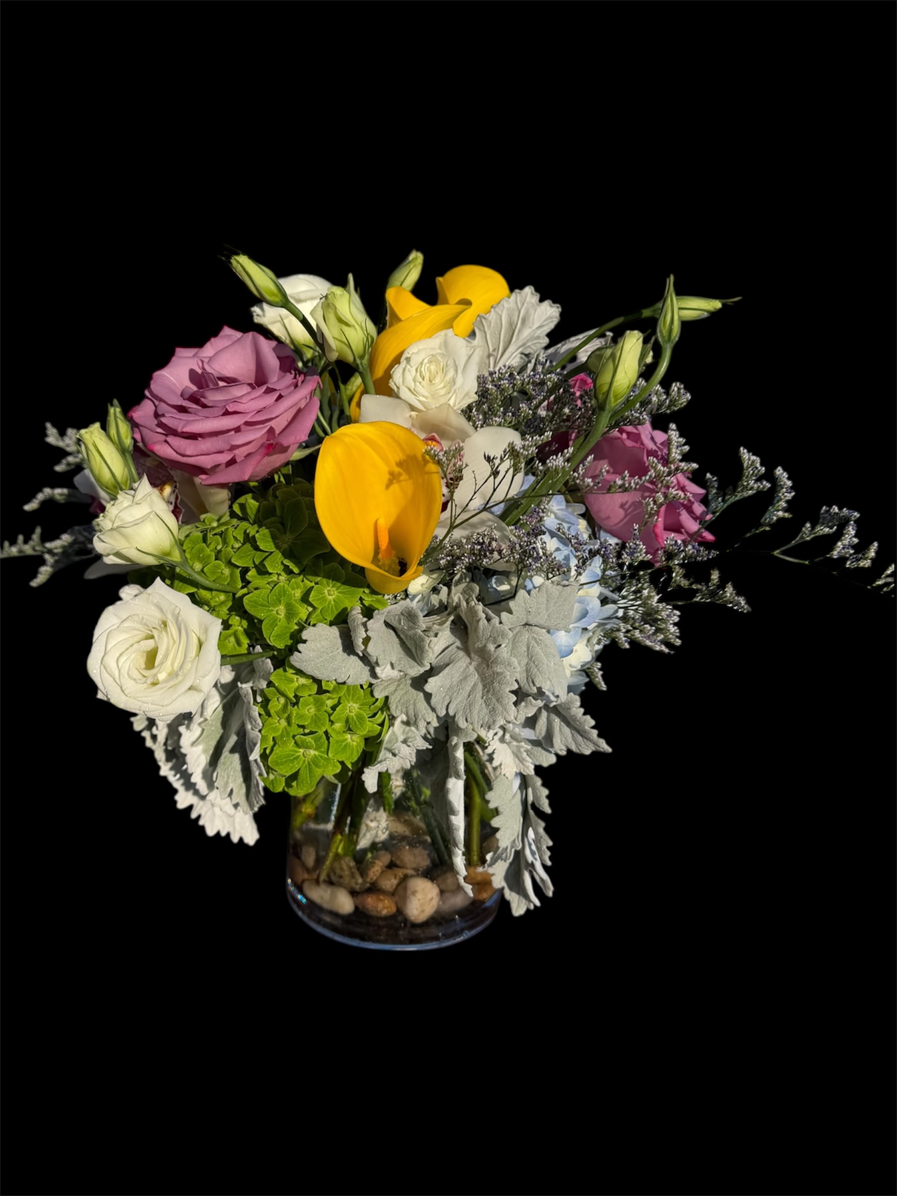 Mixed bouquet of roses, tulips, and lisianthus in a glass vase