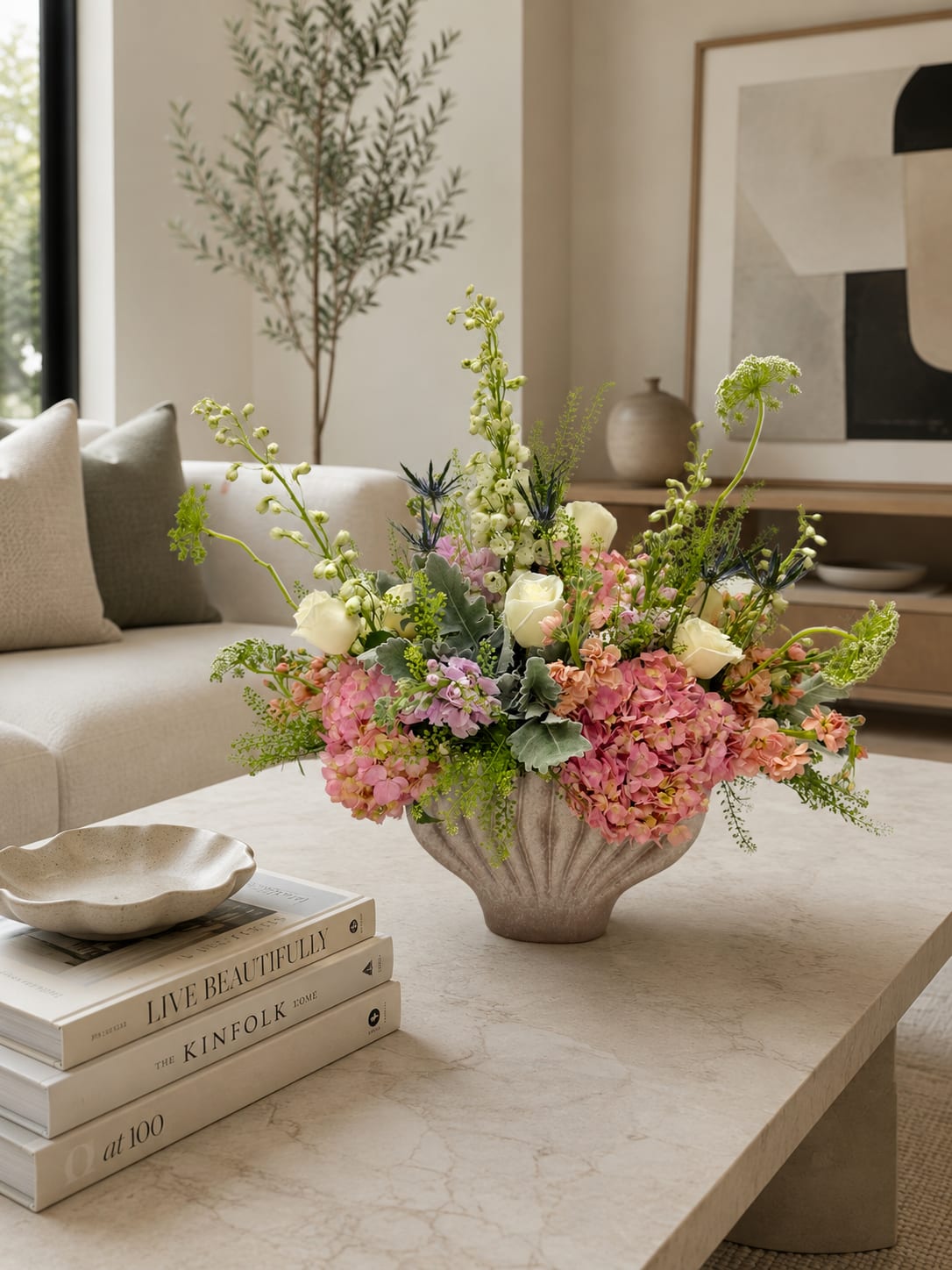 Pastel floral arrangement in a textured vase on a coffee table
