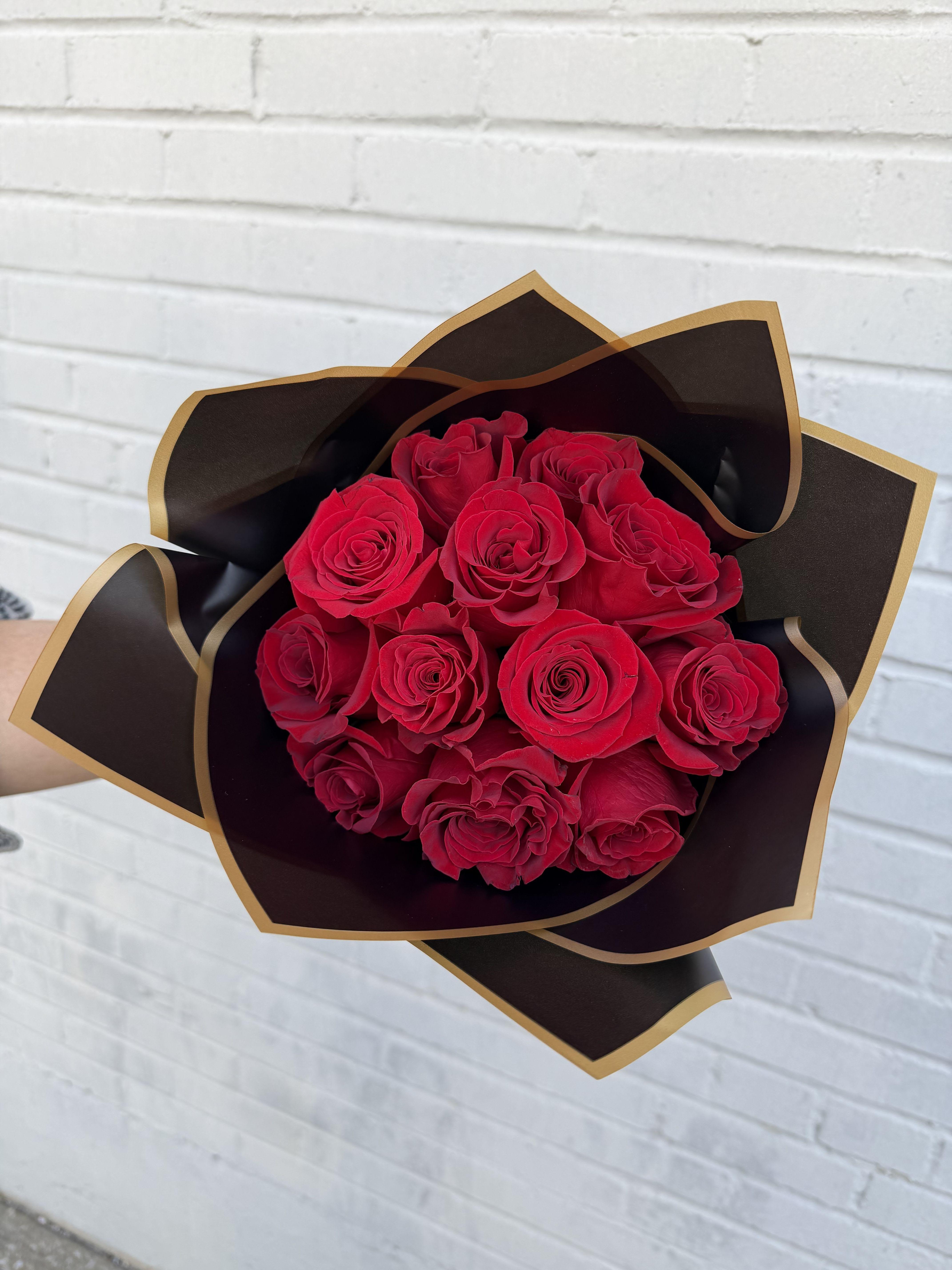 Bouquet of red roses wrapped in black and gold paper