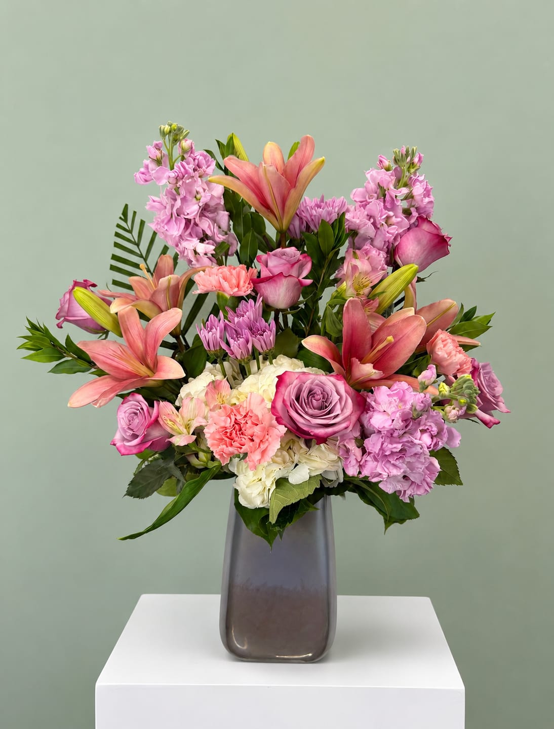 Pink and lavender mixed bouquet in a tall gray vase