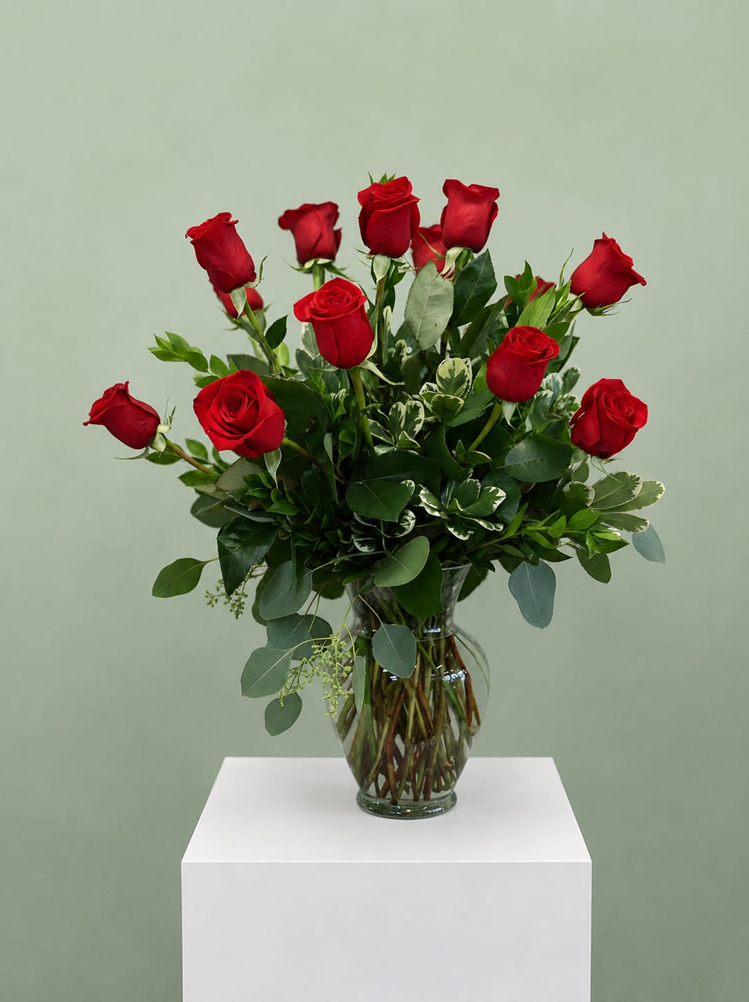 Red roses arranged in a clear glass vase