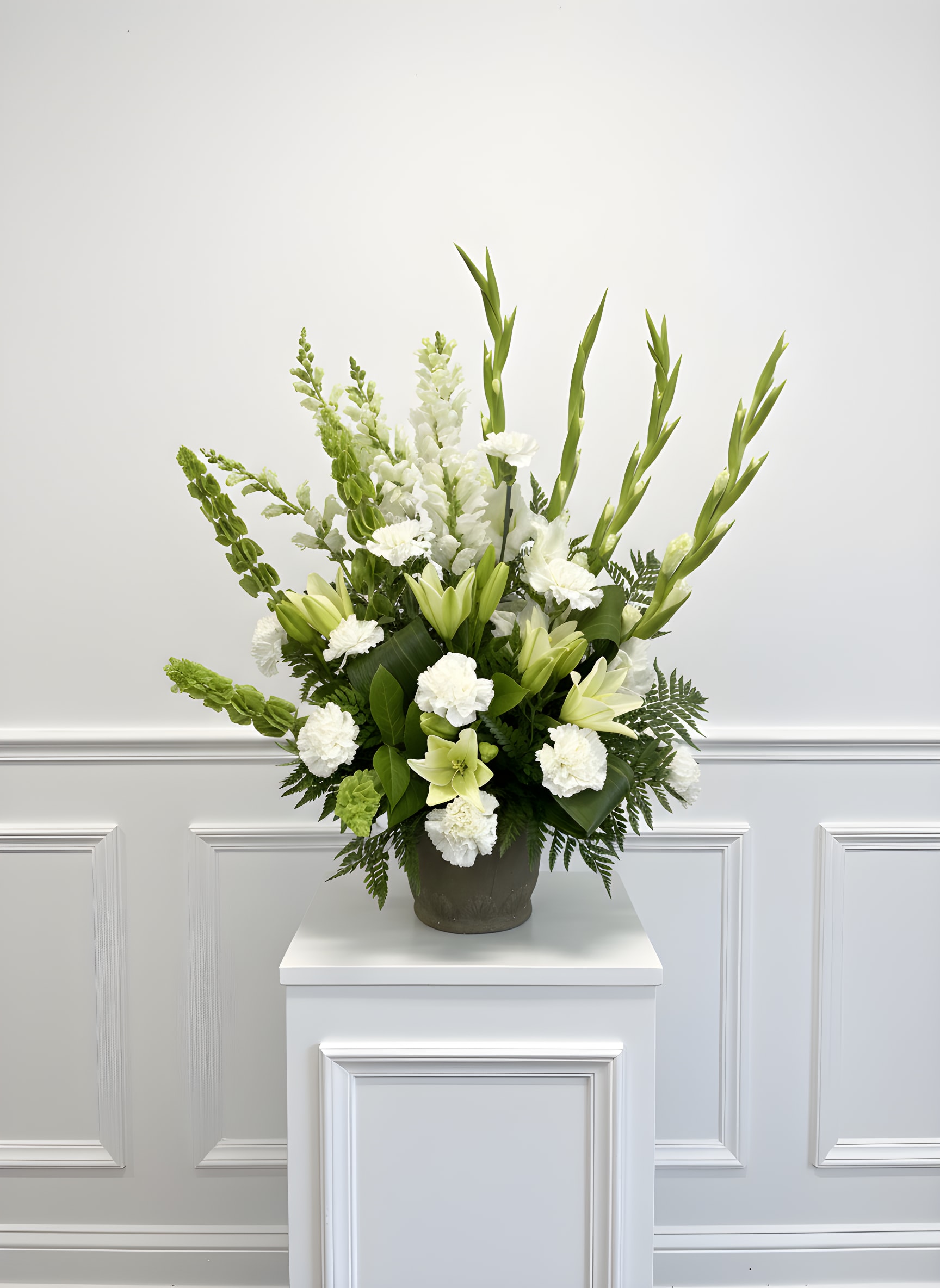 White and green floral arrangement in a dark vase