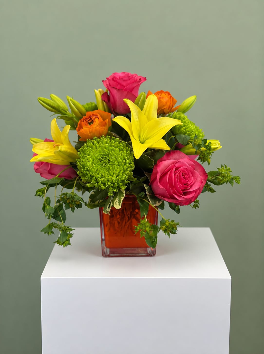 Color Me Happy - Bright, cheerful, and full of personality, Color Me Happy is a vibrant floral arrangement designed to make any occasion feel extra special. Featuring fresh pink roses, sunny yellow lilies, bright green button chrysanthemums, orange ranunculus, and seasonal greenery, this eye-catching design is arranged in a modern 5x5 glass cube vase for a fresh, contemporary look that complements any home or office.  Perfect for birthdays, celebrations, thank you gifts, congratulations, get well wishes, or simply brightening someone's day, this colorful bouquet is handcrafted by the designers at All Occasions Florist using premium, fresh flowers. Each arrangement is created with care, so slight variations may occur based on seasonal flower availability while maintaining the same bright style and overall value.  We proudly offer local flower delivery throughout Dallas and surrounding communities, with same-day delivery available on many orders placed before our daily cutoff. Whether you're celebrating a milestone or sending a thoughtful surprise, Color Me Happy delivers a beautiful burst of color that's sure to leave a lasting impression.  Container: 4x5 glass cube vase.  This description is naturally optimized for search while avoiding keyword stuffing, making it more likely to align with Google's preference for helpful, user-focused content.