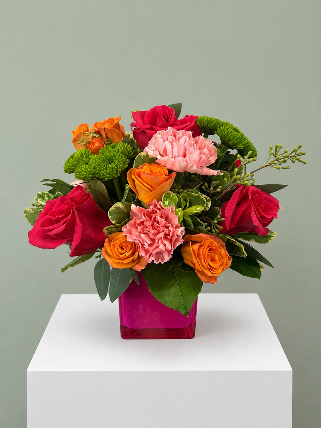 Vibrant Charm - Vibrant Charm is a cheerful floral arrangement designed to brighten any occasion with bold color and fresh blooms. Featuring vibrant pink roses, orange roses, soft pink carnations, green button poms, and seasonal greenery in a modern hot pink glass cube vase, this bouquet makes a thoughtful gift for birthdays, celebrations, thank-you gifts, get-well wishes, or simply to let someone know you're thinking of them. Its lively color palette adds warmth and happiness to homes, offices, and hospital rooms alike. Every arrangement is hand-designed by the expert florists at All Occasions Florist using the freshest flowers available, so slight variations may occur while maintaining the same overall style and value. We proudly offer same-day flower delivery throughout Dallas and surrounding communities when orders are placed before our daily delivery cutoff. Whether you're celebrating a special milestone or sending an unexpected surprise, Vibrant Charm is a beautiful way to make someone's day unforgettable.
