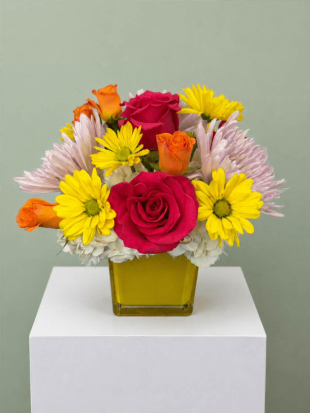 Sunny Squeeze - Sunny Squeeze is a cheerful floral arrangement bursting with bright color and fresh blooms, making it the perfect gift for birthdays, celebrations, thank-you gestures, get well wishes, or just because. Designed with vibrant hot pink roses, sunny yellow daisy poms, orange spray roses, and soft white and lavender chrysanthemums in a modern yellow glass cube vase, this joyful bouquet instantly brightens any room. Handcrafted by the expert designers at All Occasions Florist in Dallas, TX, Sunny Squeeze is created using the freshest seasonal flowers for long-lasting beauty. Whether you're sending flowers across Dallas, Richardson, Highland Park, University Park, Plano, or nearby communities, this colorful arrangement delivers happiness with every bloom. Order Sunny Squeeze today for reliable same-day flower delivery in Dallas, and share a thoughtful gift that brings sunshine, smiles, and lasting memories.