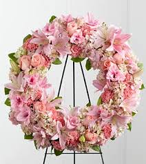 Pink floral wreath on a black stand
