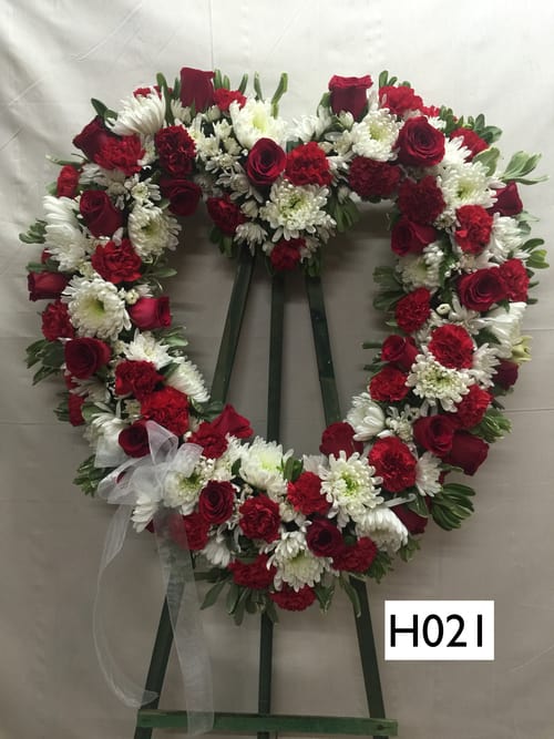 Heart-shaped red and white floral wreath on an easel