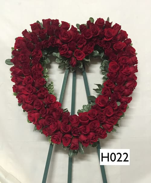 Heart-shaped wreath of red roses on a stand