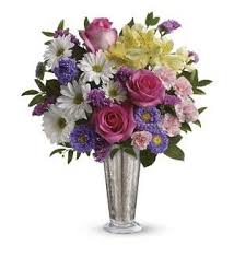 Mixed bouquet of pink roses and purple daisies in a silver vase
