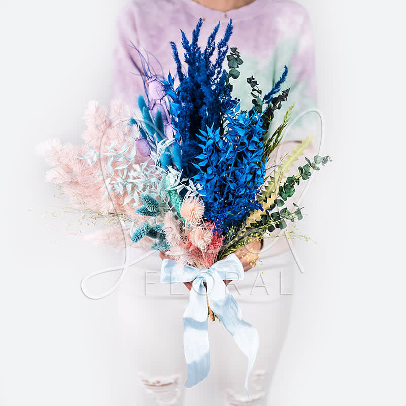 Colorful bouquet with blue and pink dried flowers tied with a ribbon