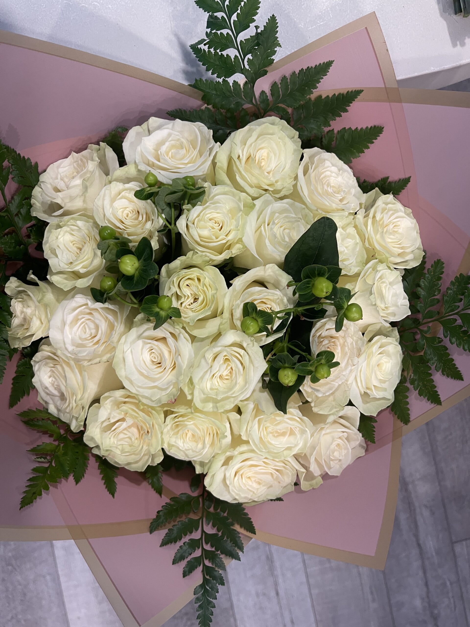 Bouquet of white roses wrapped in pink paper