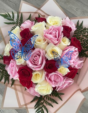 Bouquet of pink, red, and white roses with blue butterfly picks