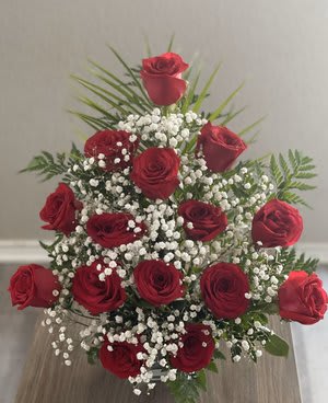Red roses arranged with baby's breath in a vase