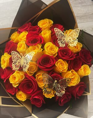Bouquet of red and yellow roses with butterfly decorations