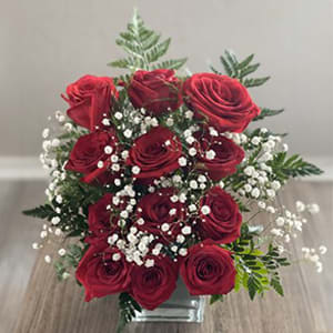Red roses with baby's breath in a clear glass vase