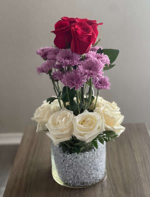 Red and white roses arranged in a glittery glass vase