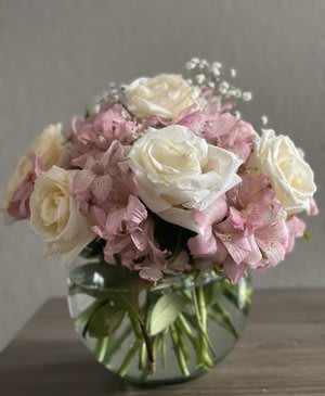 Pink and white roses with pink hydrangeas in a glass vase