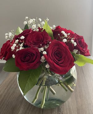 Red roses in a clear glass vase with white baby's breath