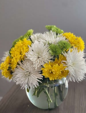White and yellow chrysanthemum bouquet in a glass vase