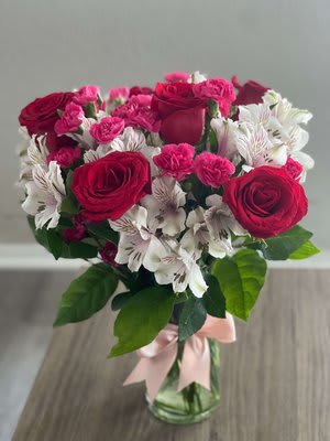 Bouquet of pink roses and white alstroemeria in a glass vase
