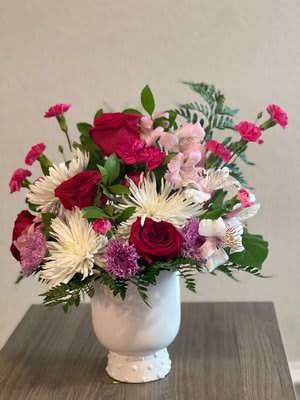 Pink and red flower arrangement in a white vase
