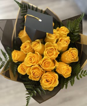 Bouquet of yellow roses wrapped in dark paper with a black tag