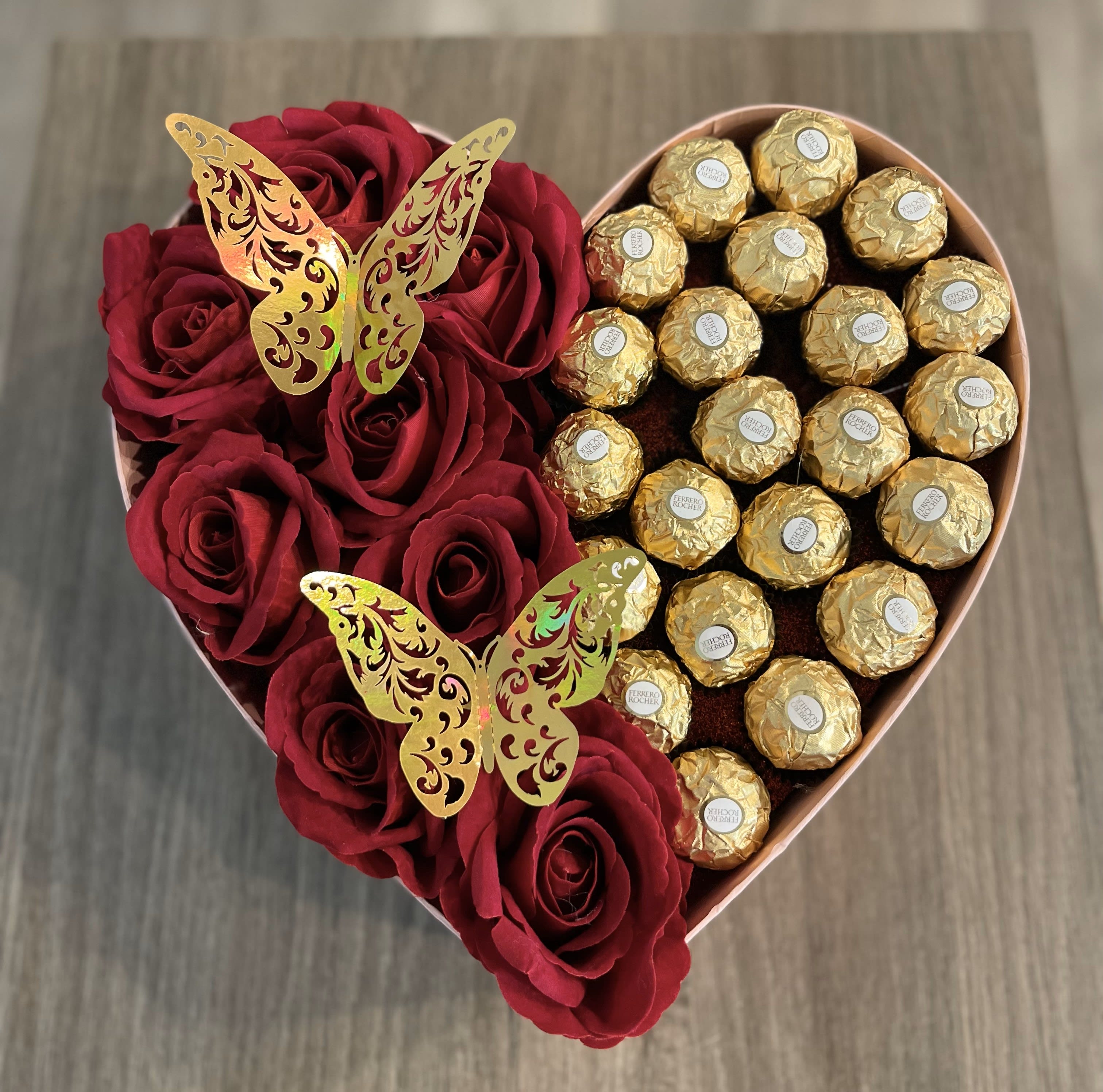 Heart-shaped box with red roses and gold-wrapped chocolates