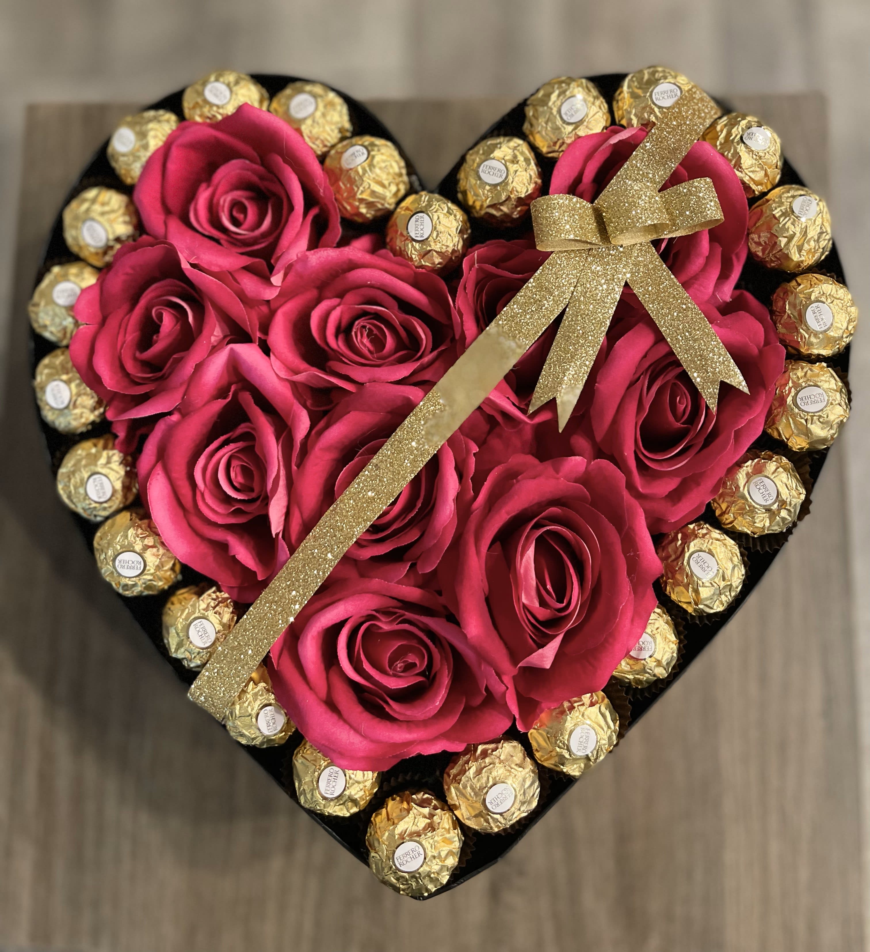 Heart-shaped box with pink roses and gold-wrapped chocolates