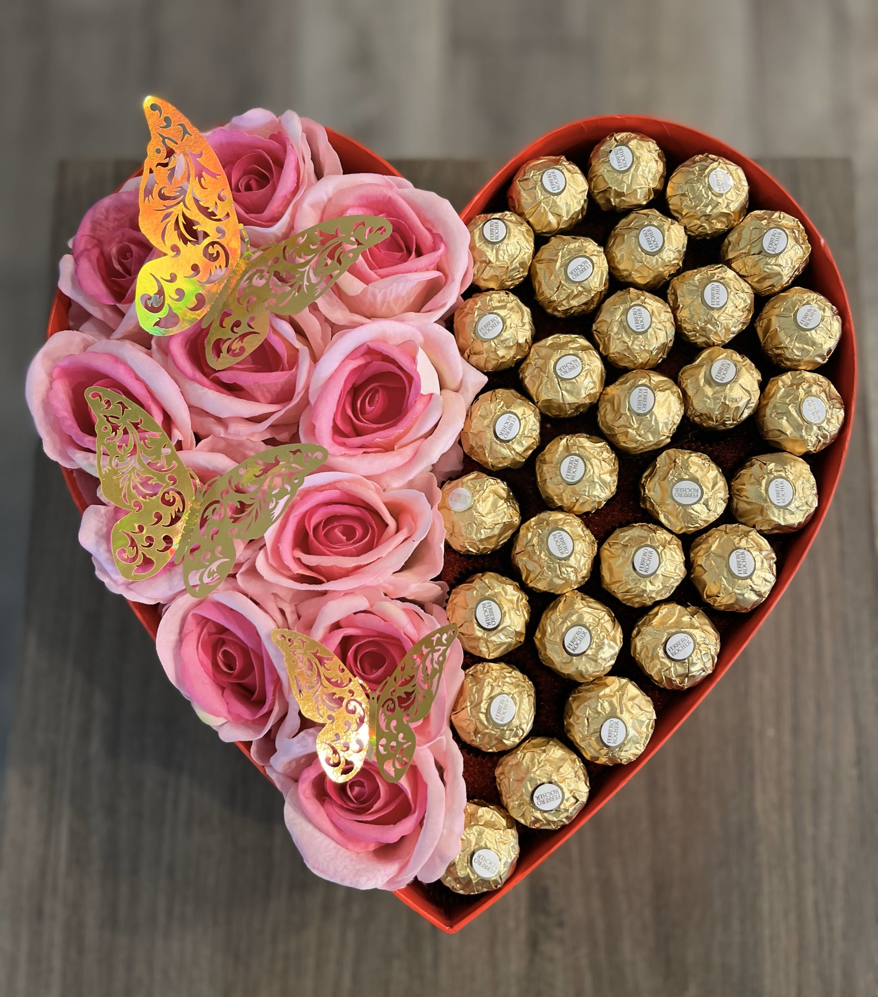 Heart-shaped box with pink roses and gold-wrapped chocolates