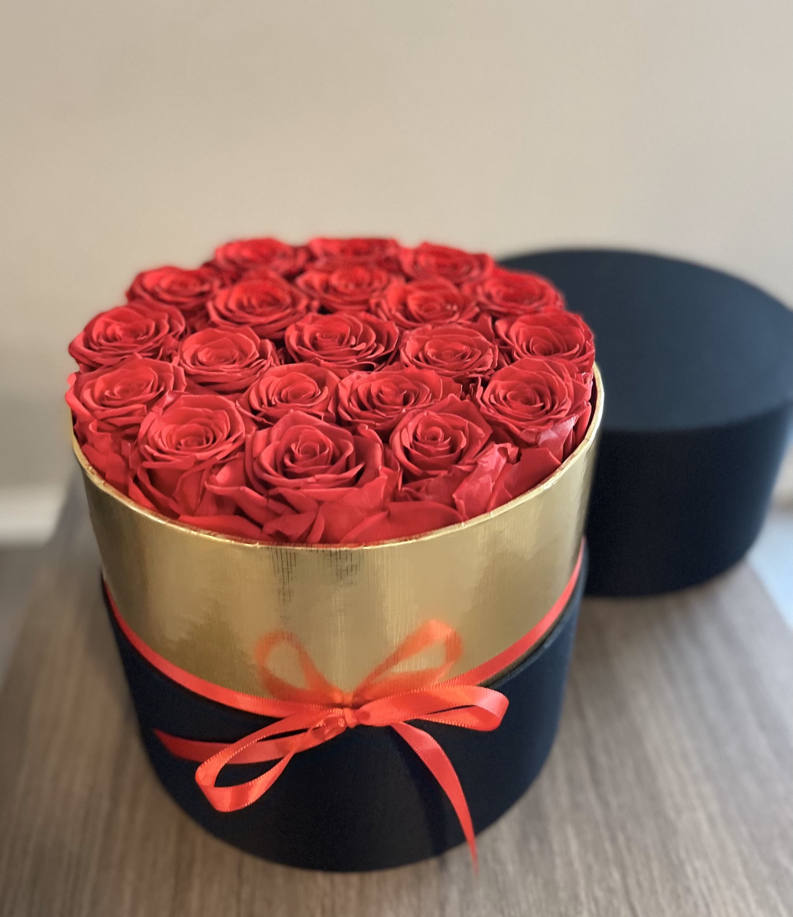 Round box of red roses tied with a ribbon
