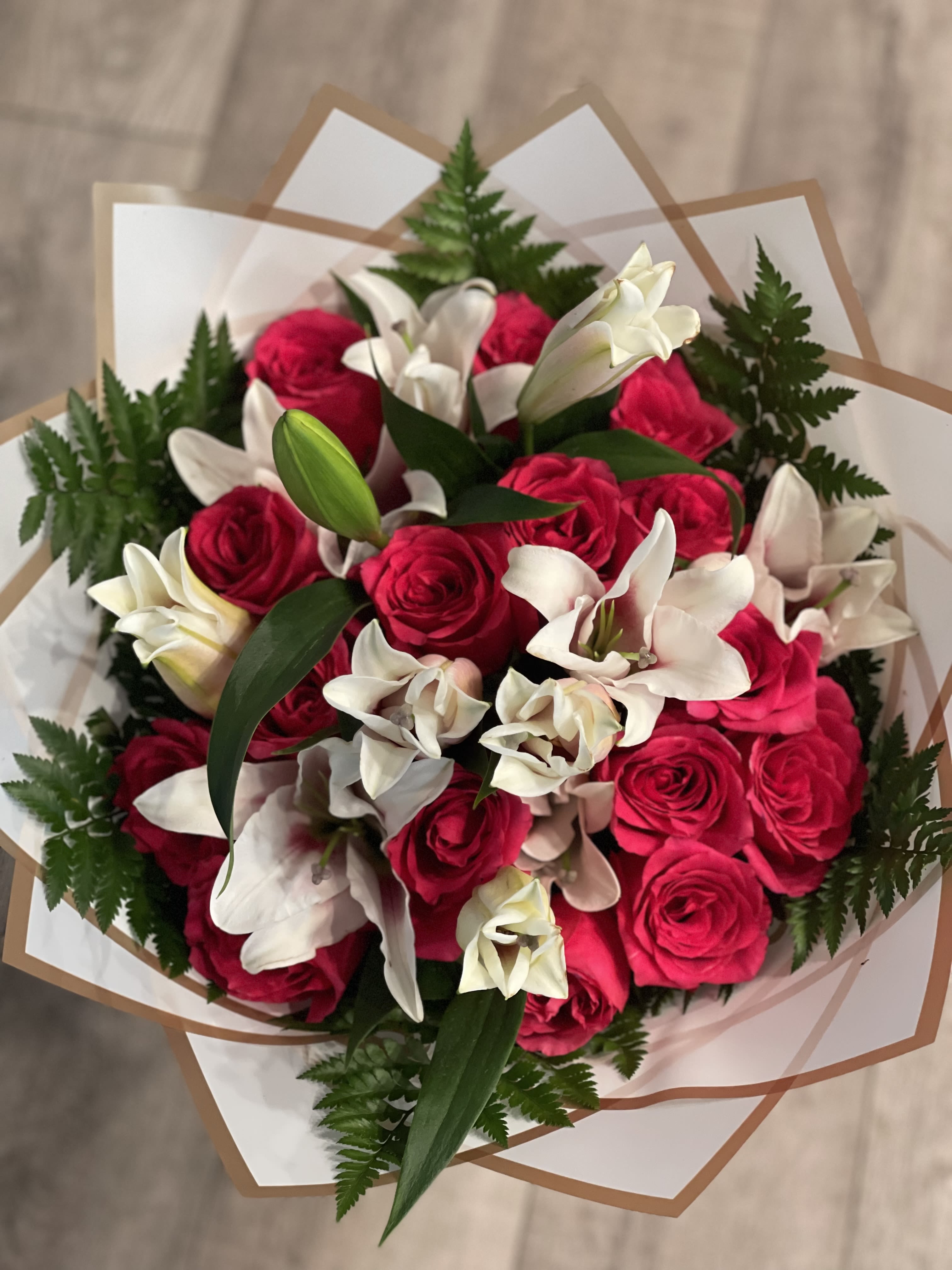 Bouquet of hot pink roses and white lilies wrapped in paper