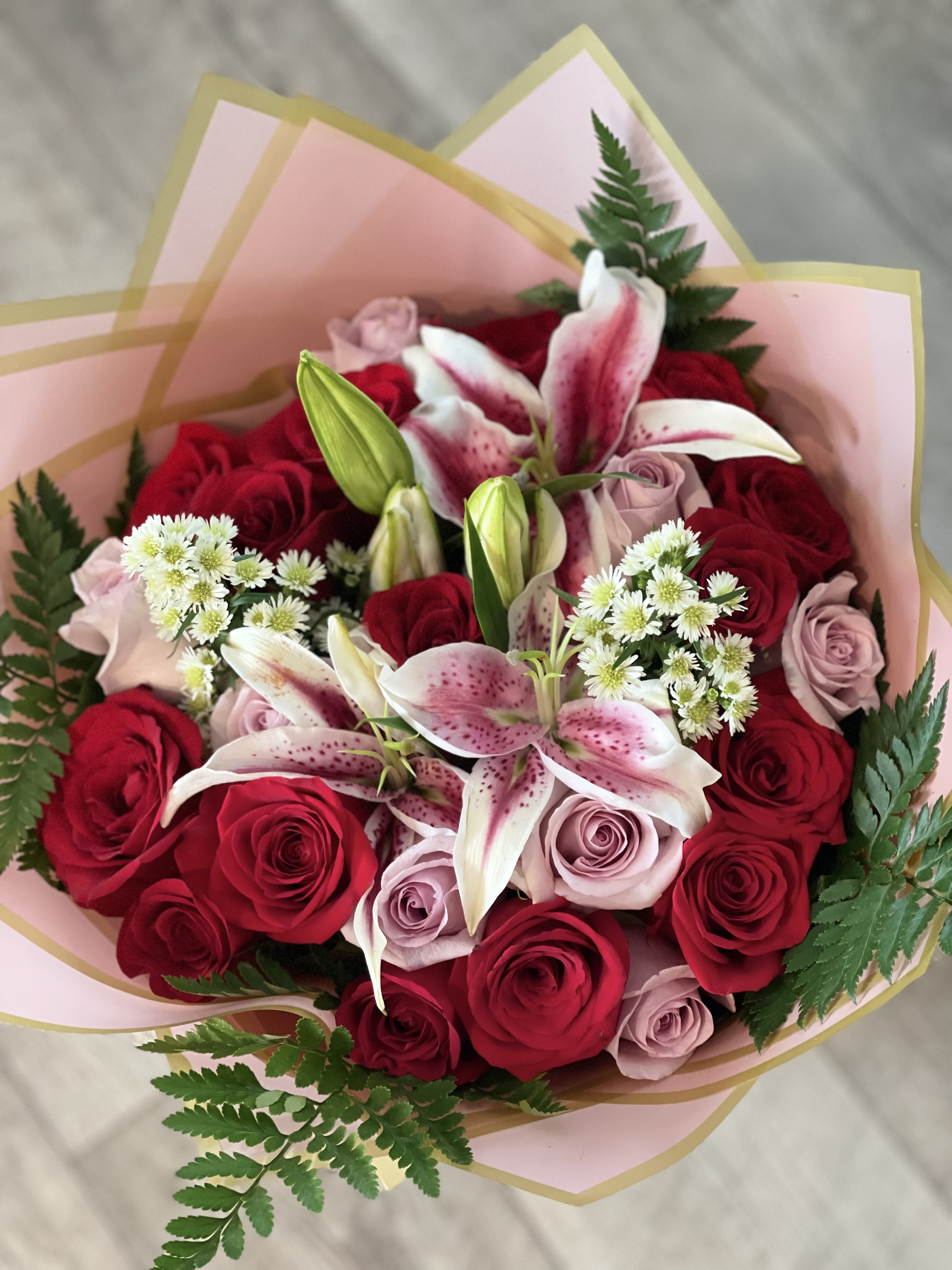 Bouquet of red and blush roses with pink lilies and white filler flowers