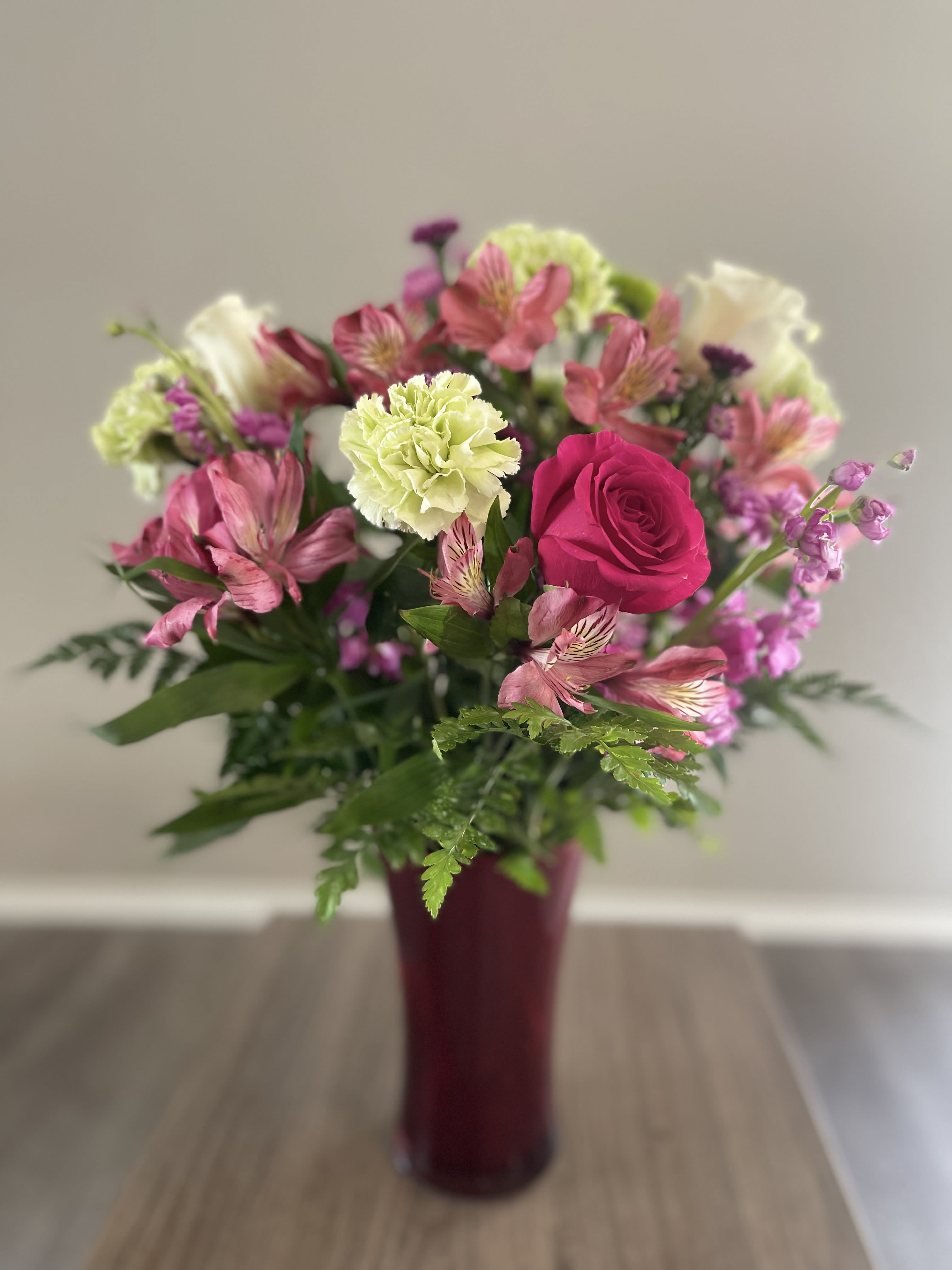 Pink and white mixed bouquet in a burgundy vase