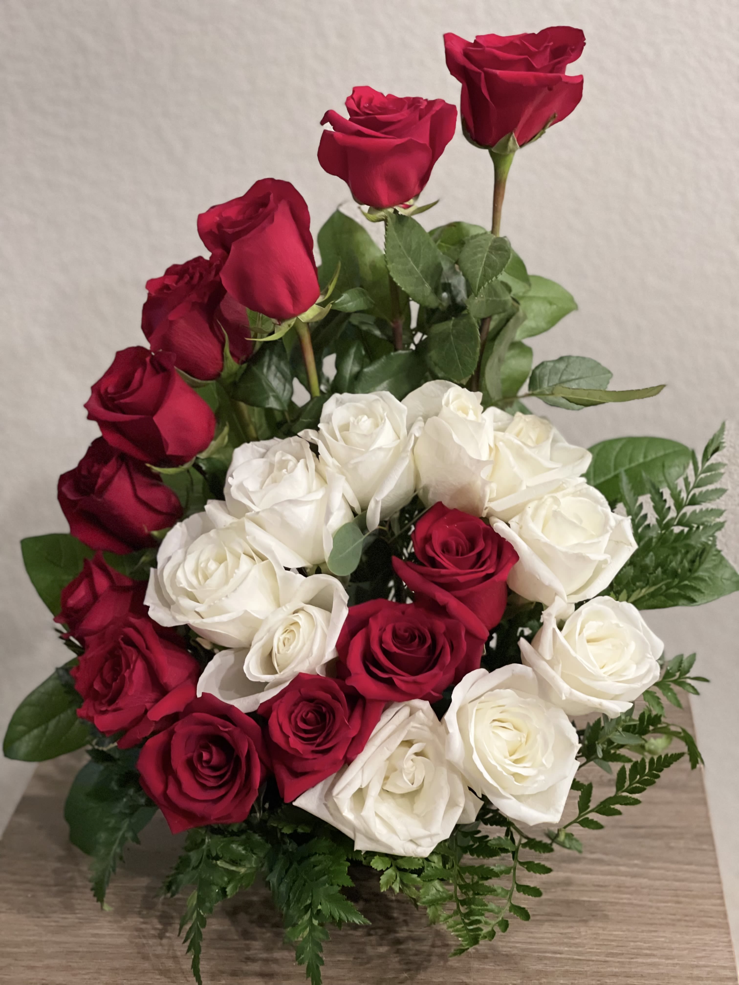 Bouquet of red and white roses with greenery