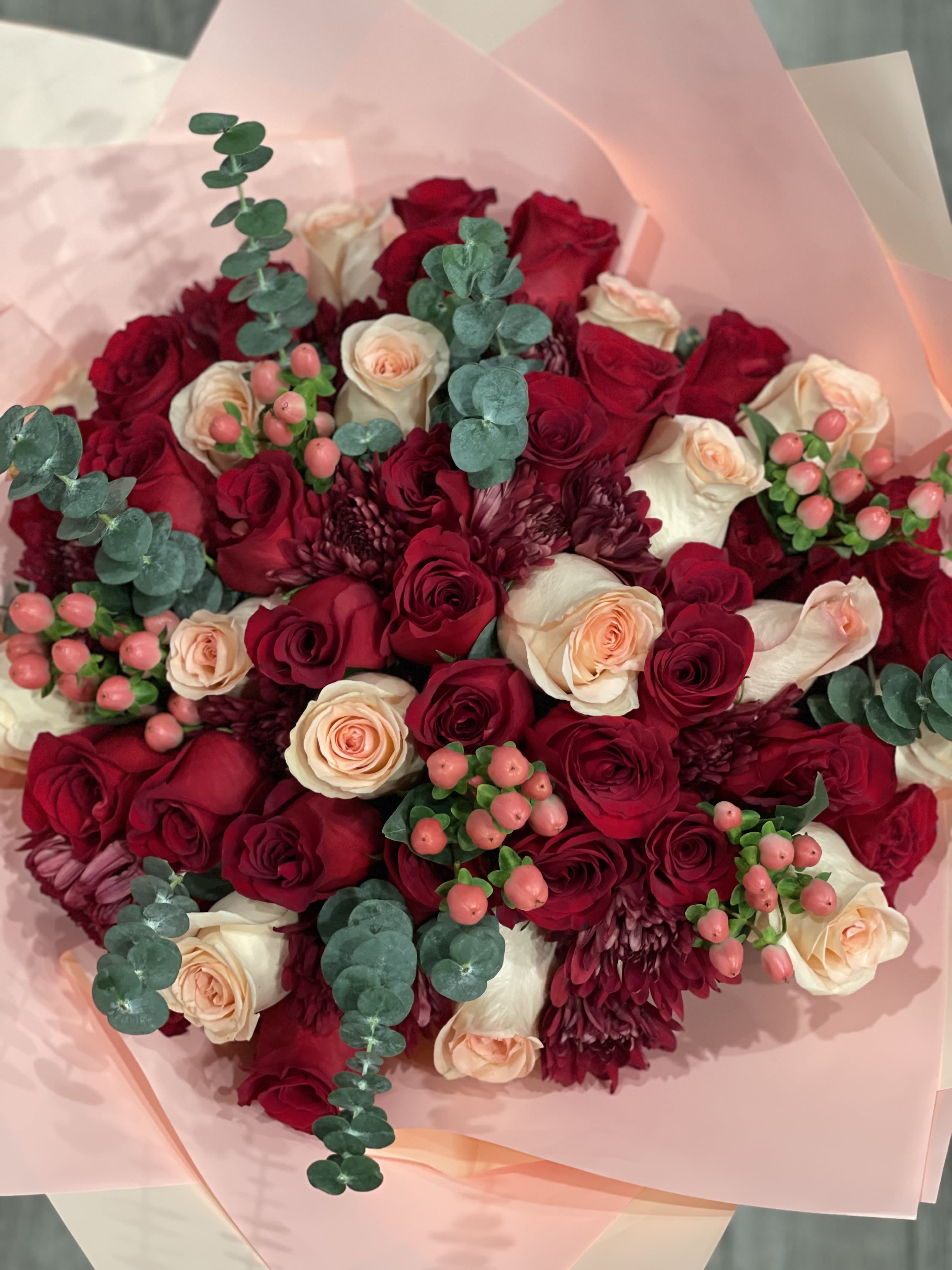 Bouquet of red and cream roses with burgundy blooms and eucalyptus