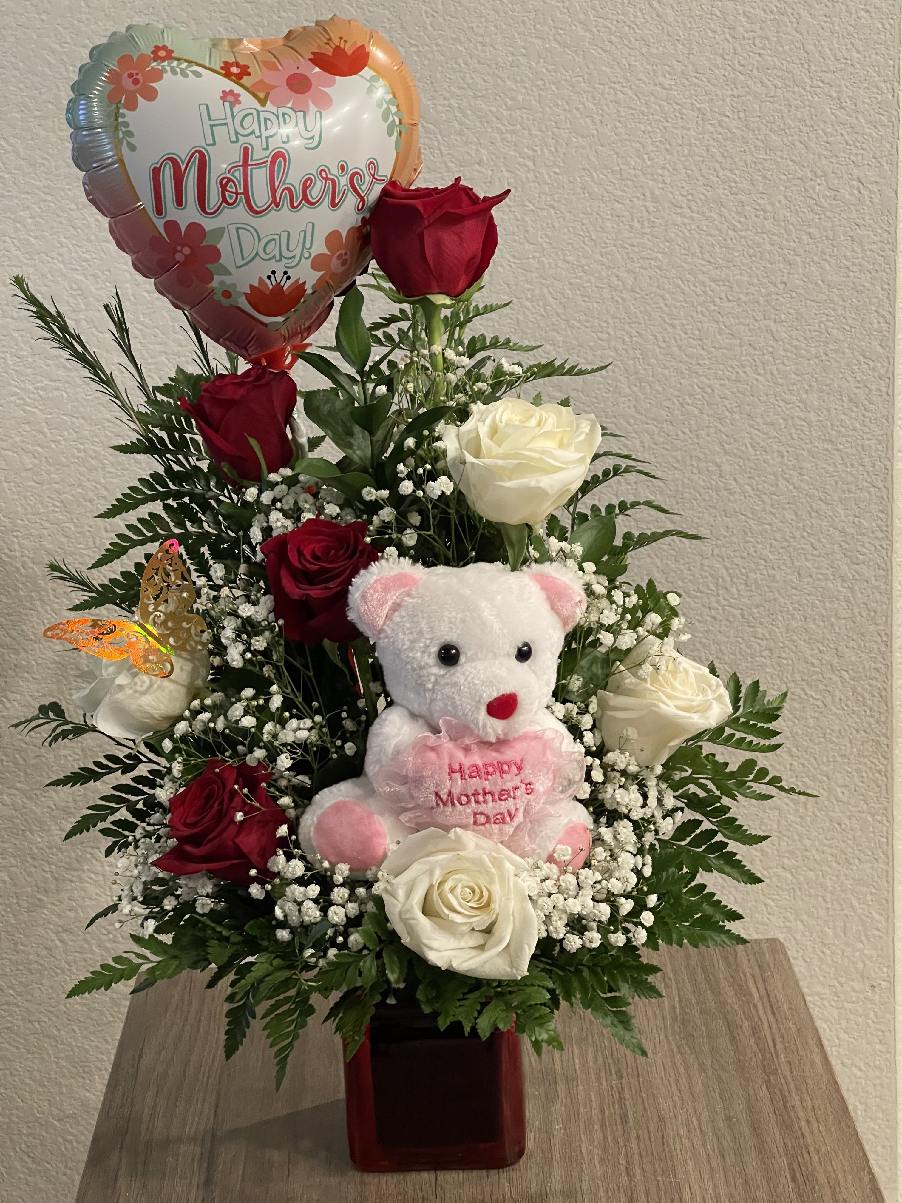 To Mum with Love - Best gift for Mother’s Day that will definitely make mom happy and make her smile. This arrangement is made with red and withe Premium roses, baby’s breath flowers and assorted greenery on a glass red square vase. The teddy bear and the balloon give the final touches for the perfect gift. 