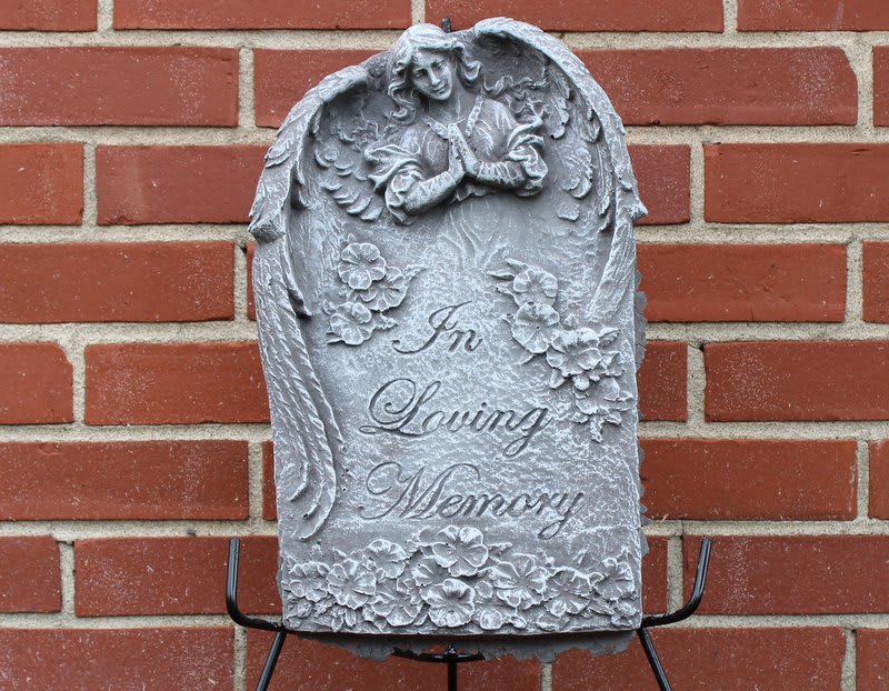 Gray memorial plaque with angel relief and the words In Loving Memory