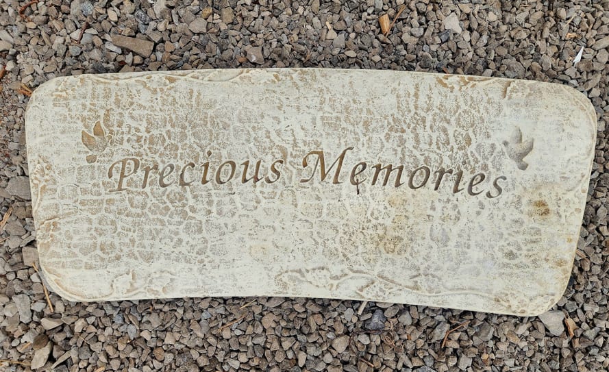 Stone memorial plaque engraved with "Precious Memories"