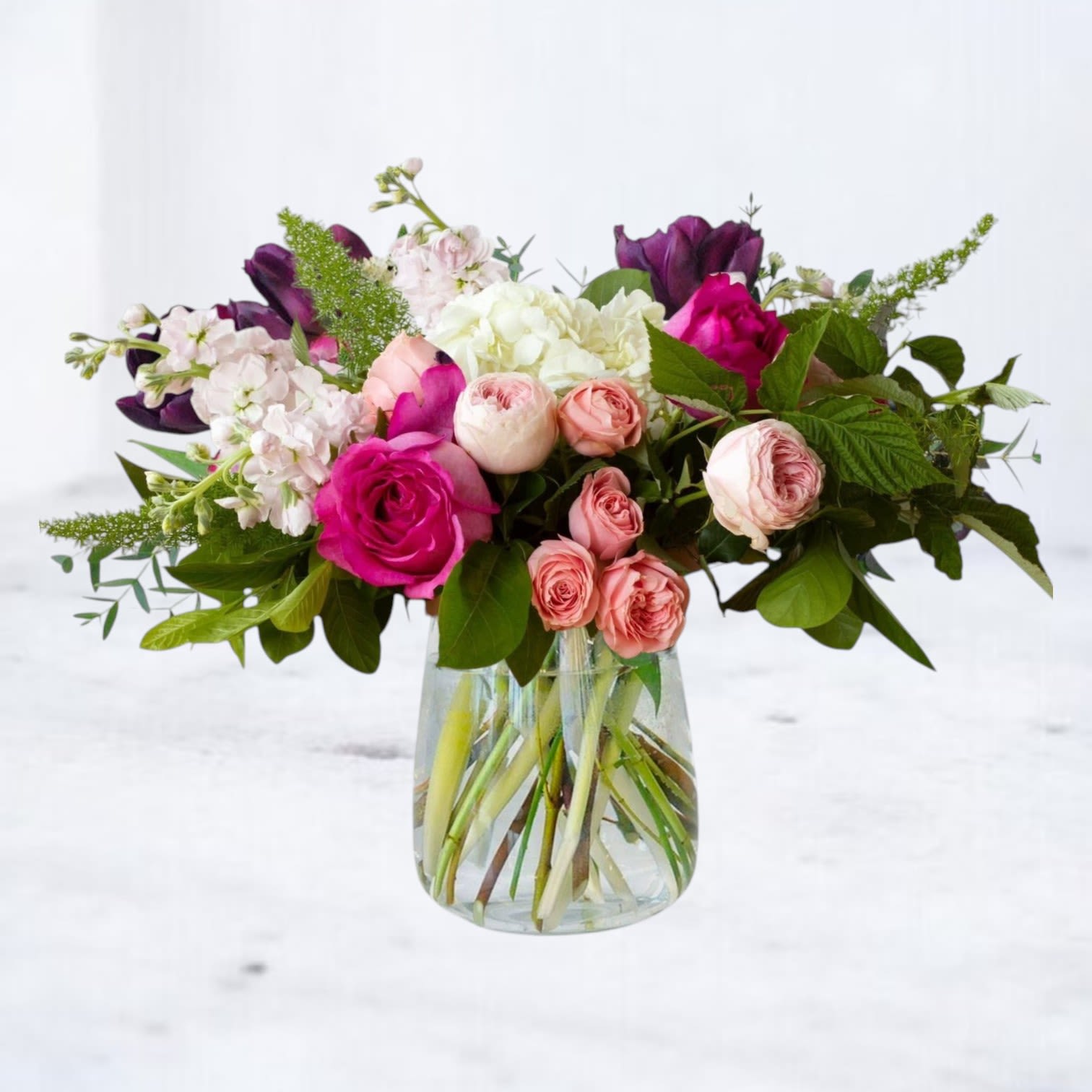 Mixed pink and white flowers in a clear glass vase