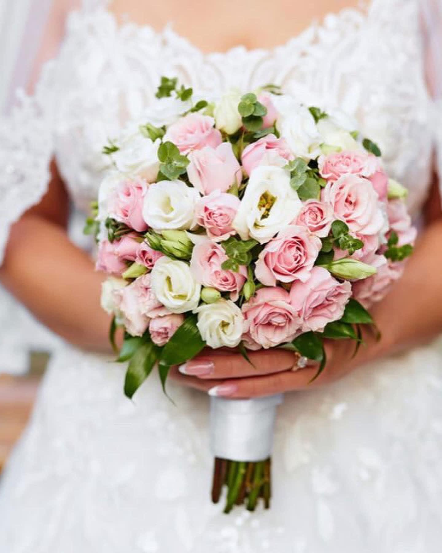 Bride holding a bouquet of pink and white roses