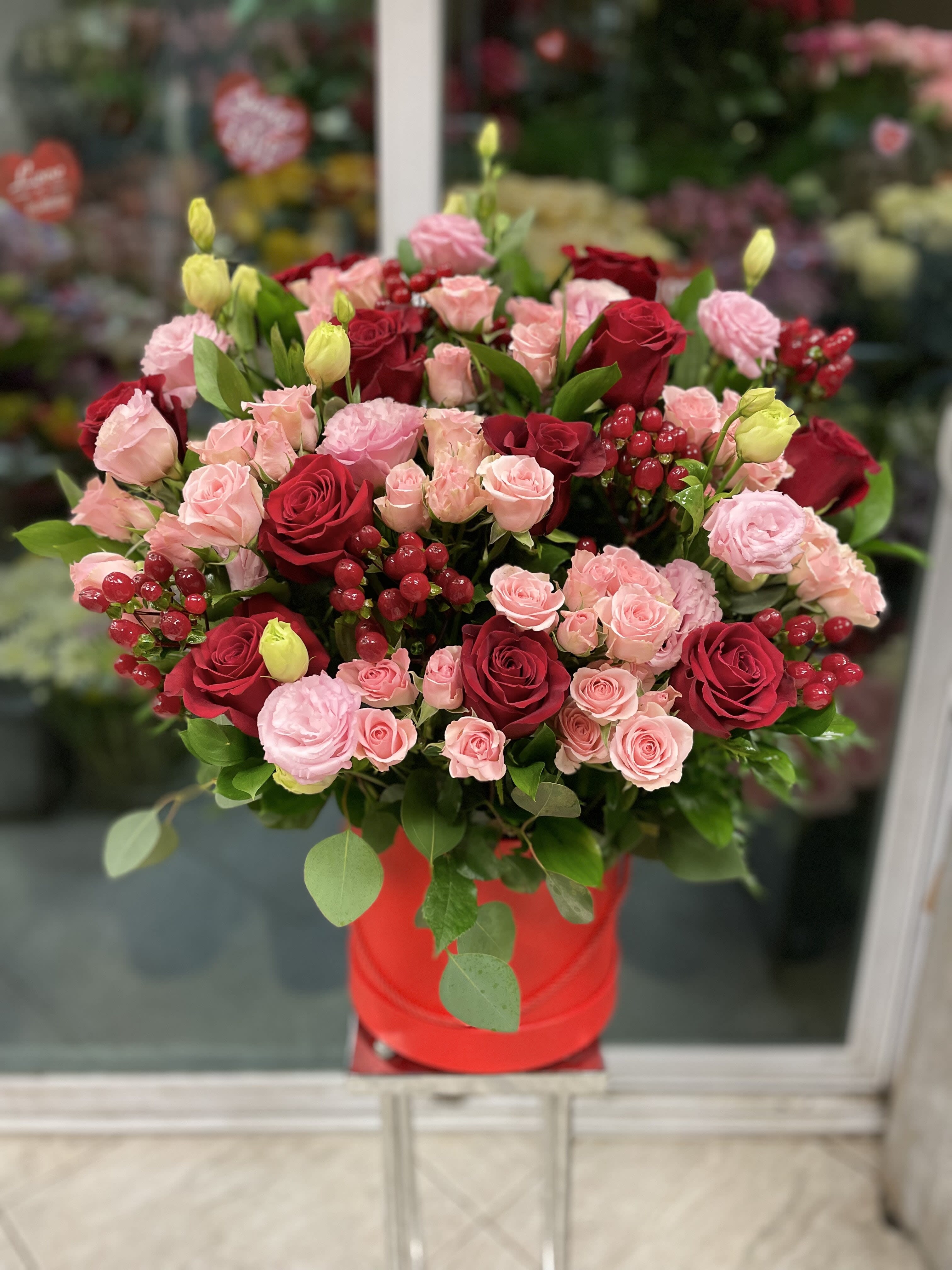 Bouquet of red and pink roses in a red hat box