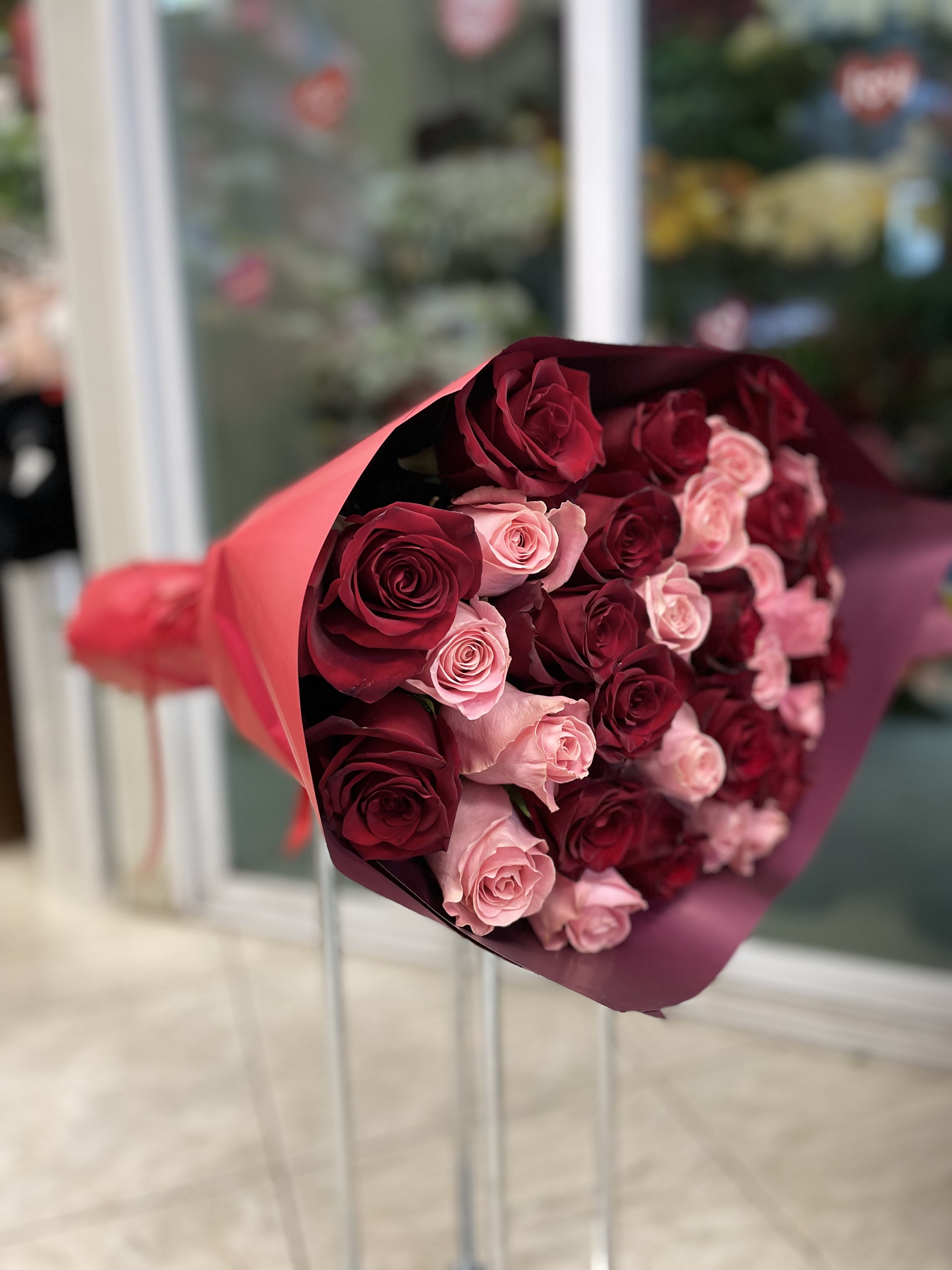 Bouquet of red and pink roses wrapped in burgundy paper