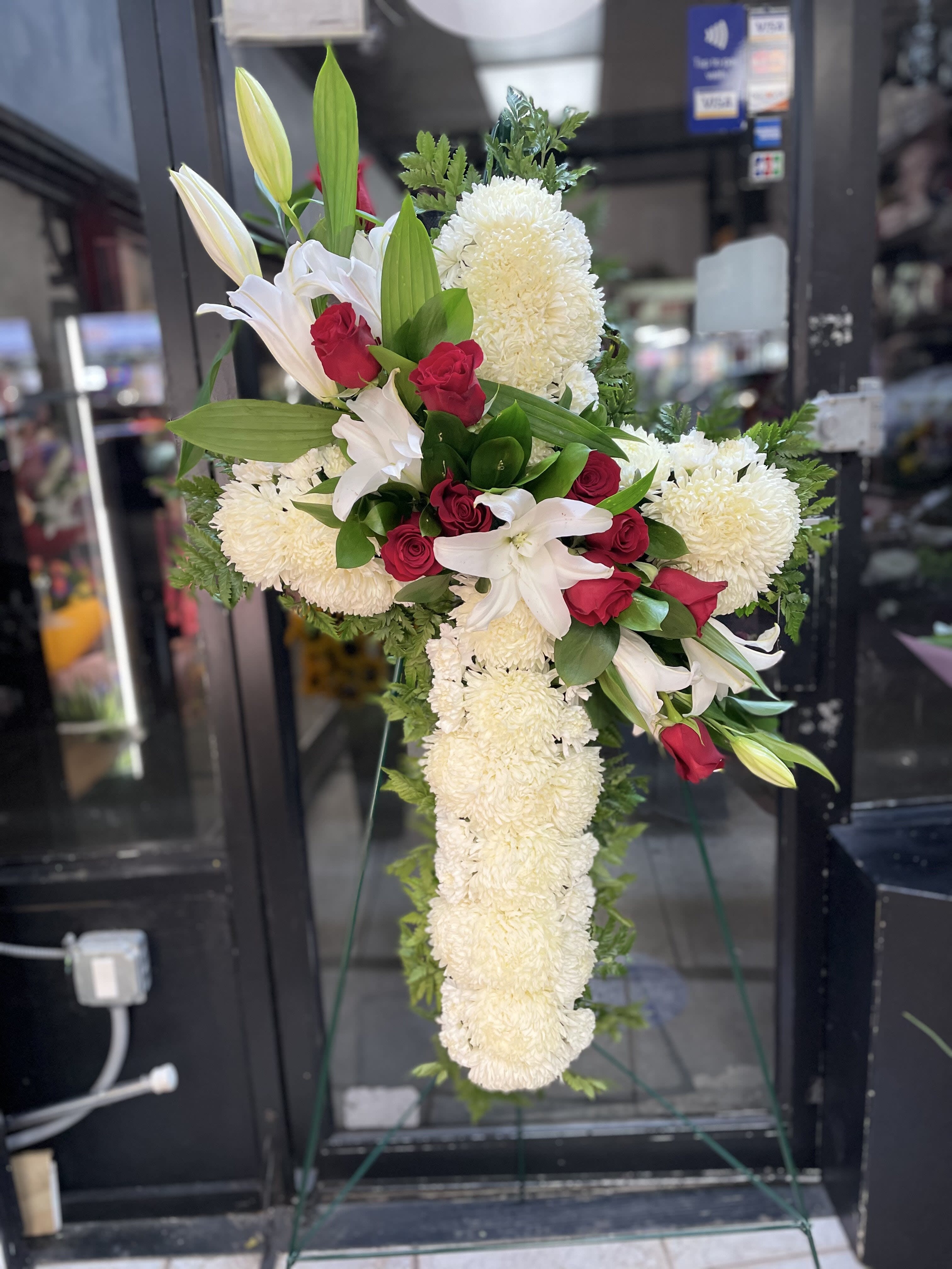 White lilies and red roses in a tall standing spray