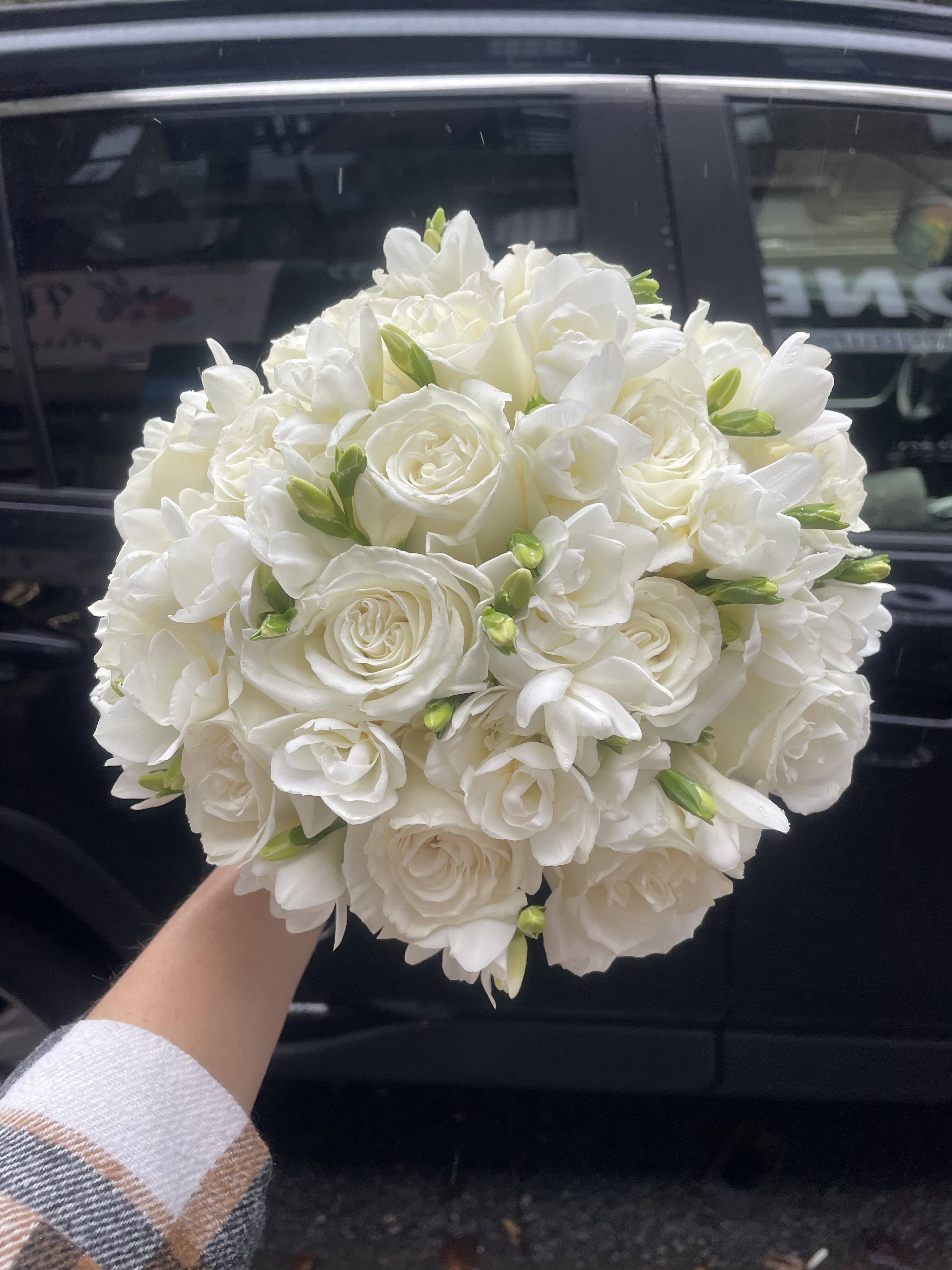 Round bouquet of white roses and white freesia