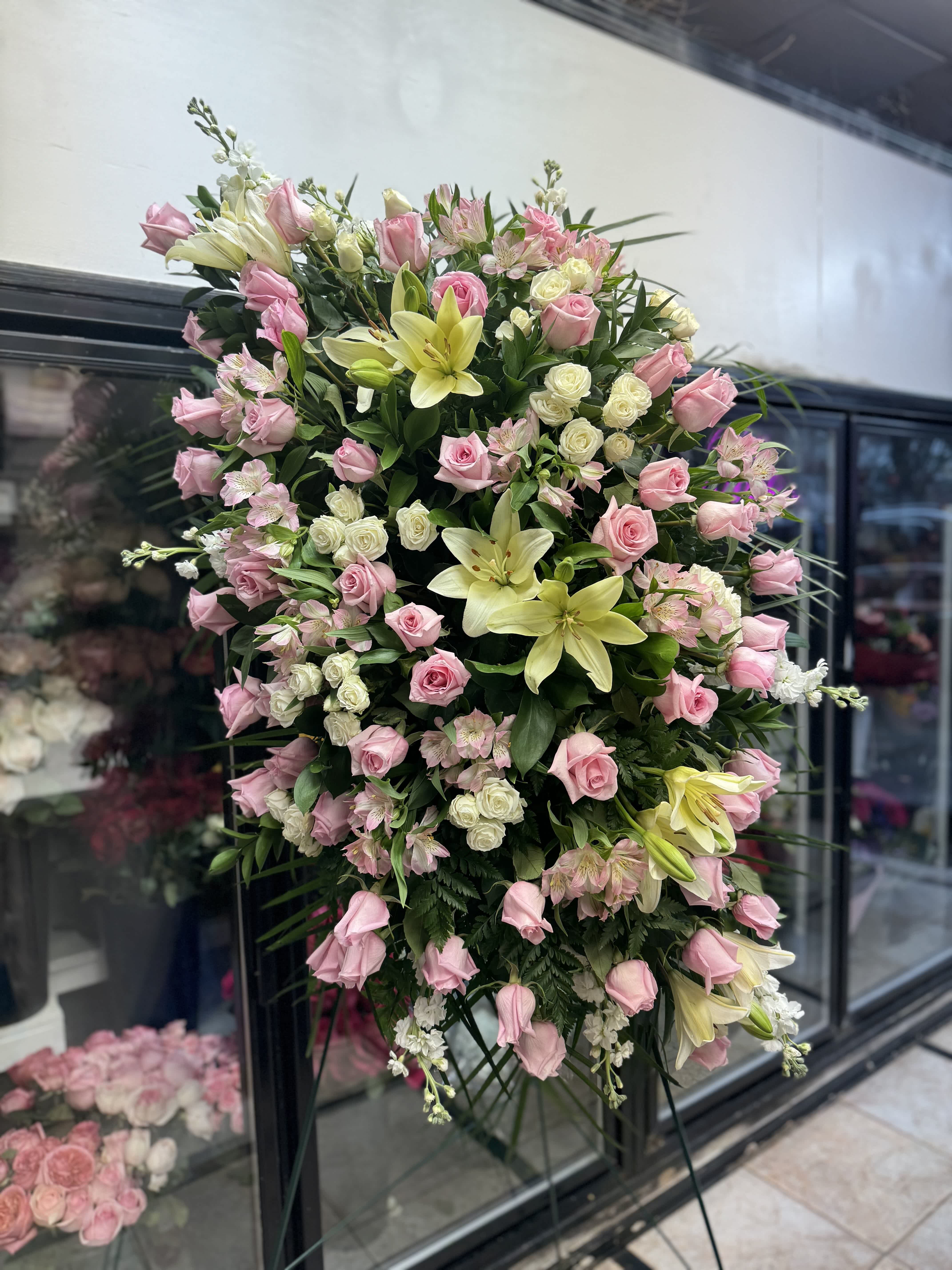 Large standing spray of pink roses and pale lilies