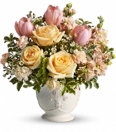 Pink tulips and pale yellow roses in a white vase