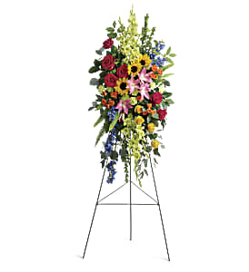 Tall standing floral spray with mixed colorful flowers on an easel